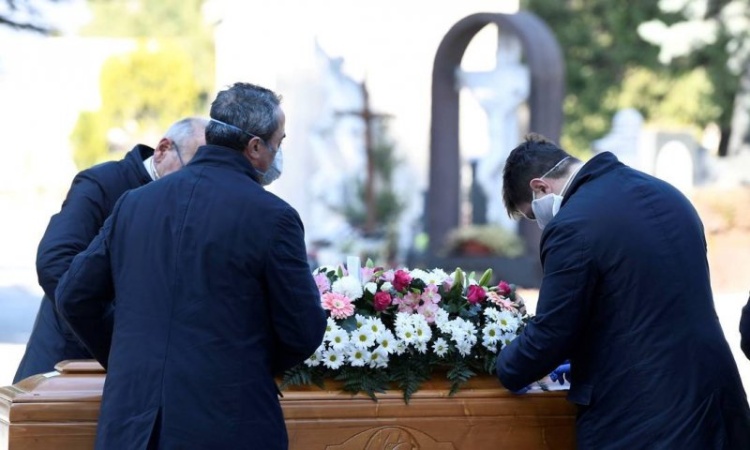 
Homens com máscaras de proteção carregam caixão de vítima do novo coronavírus em cemitério de Bergamo, na Itália Foto: Flavio Lo Scalzo / REUTERS